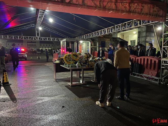 明阳山殡仪馆外，献花的群众鞠躬致敬