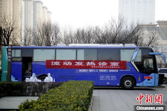 图为停靠在广场上的流动发热诊室