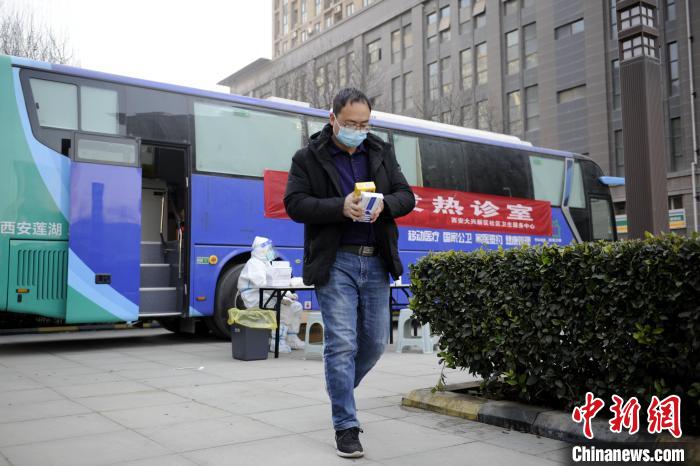 手捧刚买的药品离开移动发热诊室